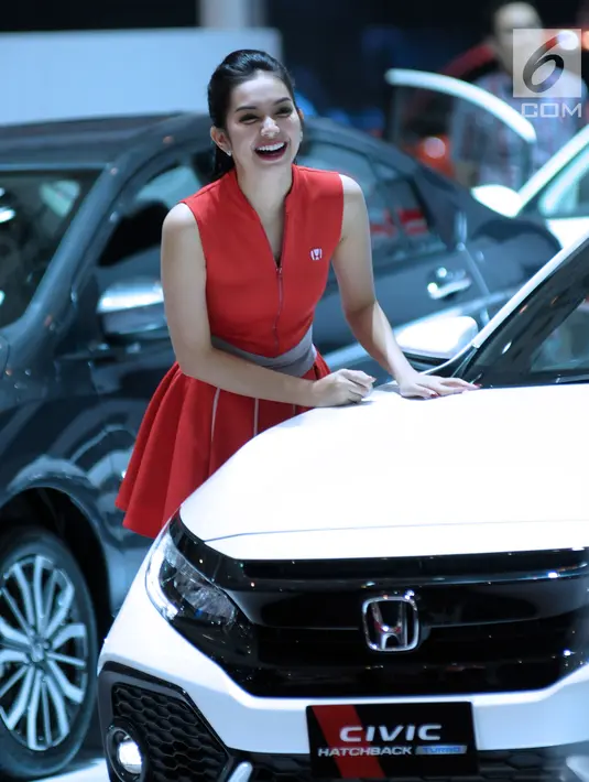 Sales Promotion Girl tersenyum menyambut pengunjung Indonesia International Motor Show 2018 di JIExpo, Jakarta, Kamis (19/4). IIMS 2018 diselenggarakan hingga 29 April mendatang. (Liputan6.com/Helmi Fithriansyah)