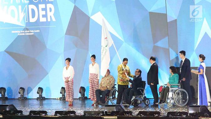 Gubernur DKI Jakarta Anis Baswedan menyerahkan bendera Asian Paralympic Committe kepada Presiden Para Committe Majid Rashed saat Penutupan Asian Para Games 2018  Stadion Madya, Gelora Bung Karno, Jakarta, Sabtu (13/10). (merdeka.com/Imam Buhori)