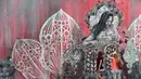 Pengunjung melihat mural yang dibuat oleh seniman Shepard Fairey di kawasan Wynwood, Miami, Florida pada 28 September 2016. Goldman Properties menggelar pameran mural untuk merevitalisasi lingkungan. (AFP PHOTO / Rhona WISE)