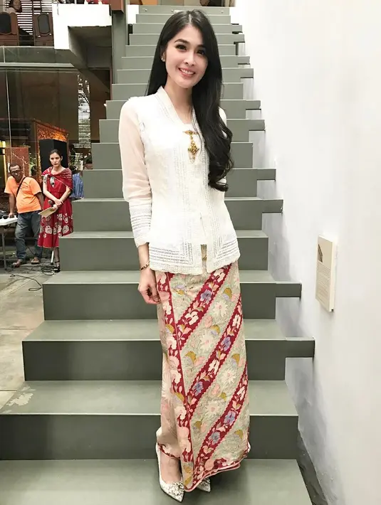 Pesona anggun Sandra Dewi kenakan kebaya kartini warna putih dan kain batik nuansa krem-merah. [@sandradewi88]