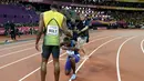 Pelari AS, Justin Gatlin berlutut di hadapan Usain Bolt usai menjadi juara pada lomba lari 100 meter Kejuaraan Dunia Atletik 2017 di Stadion London, Minggu (6/8). Gatlin menjadi pelari tercepat dengan catatan waktu 9.92 detik. (AP/Matthias Schrader)