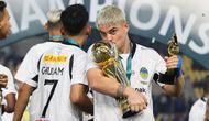 Pemain PSIM Yogyakarta, Rafinha mencium trofi Pegadaian Liga 2 2024/2025 setelah timnya berhasil menang atas Bhayangkara FC dalam laga final yang berlangsung di Stadion Manahan, Solo, Jawa Tengah, Rabu (26/02/2025). (Bola.com/Abdul Aziz)