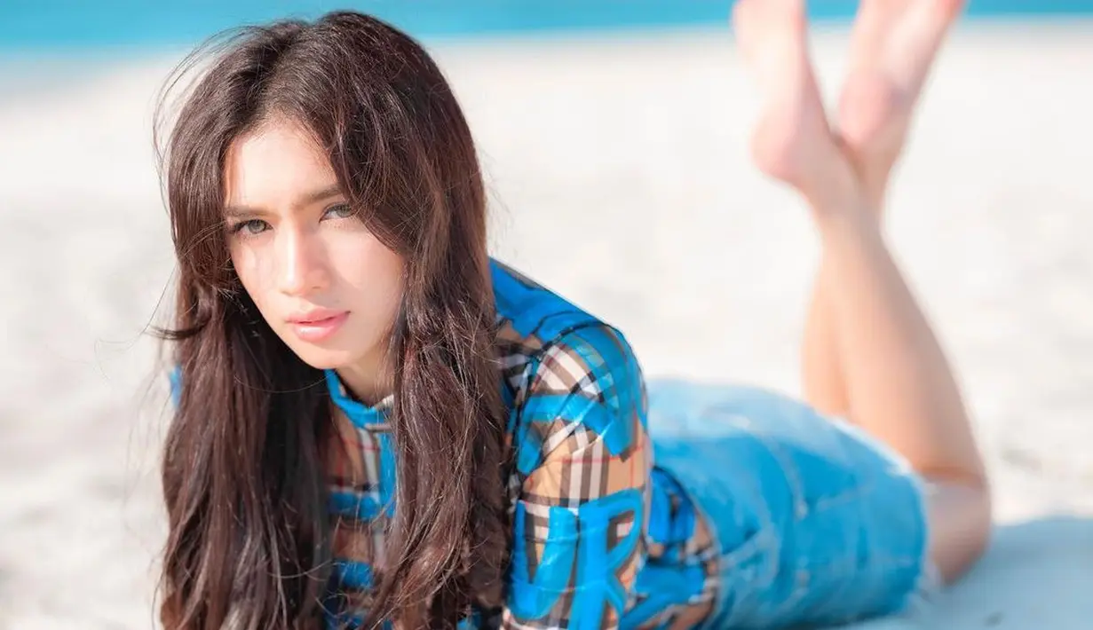 Seperti ini potret terbaru yang diunggah Angel Karamoy saat tiduran di pasir pantai. (FOTO: instagram.com/realangelkaramoy)