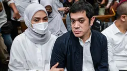 Sebelumnya, Muhammad Kerry Adrianto Riza didakwa melakukan pengaturan agar PT Jenggala Maritim Nusantara (JMN), perusahaan miliknya, memenangkan pengadaan sewa kapal dalam kerja sama dengan Pertamina. Tampak dalam foto, mantan Wakil Direktur Optimalisasi Produk di PT Kilang Pertamina Internasional, Muhammad Kerry Adrianto Riza (kanan), yang juga putra pengusaha Riza Chalid, didampingi istrinya Atya Sardadi (kiri), sesaat sebelum mengikuti sidang pembacaan vonis di Pengadilan Tindak Pidana Korupsi, Jakarta, Kamis 26 Februari 2026. (BAY ISMOYO/AFP)