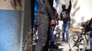 Petugas polisi membawa senjata di depan markas polisi selama protes untuk mengecam tata kelola polisi yang buruk di Port-au-Prince, Haiti, 26 Januari 2023. Pada Oktober 2022, pemerintah Henry mengimbau komunitas internasional mengirimkan pasukan keamanan multinasional untuk membantu memulihkan ketertiban. (AP Photo/Odelyn Joseph)