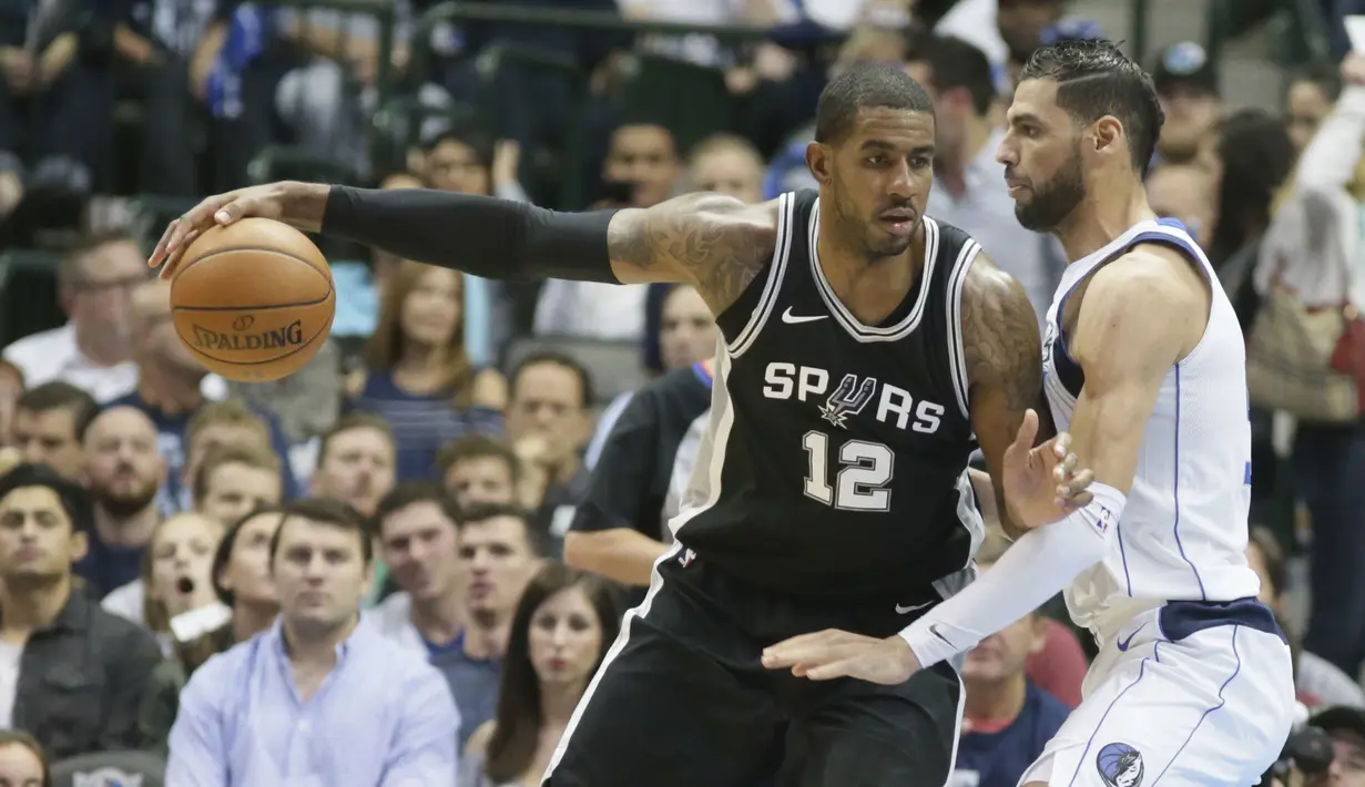 Pemain San Antonio Spurs, LaMarcus Aldridge (12) mencoba melewati adangan pemain Dallas Mavericks, Salah Mejri (50) pada laga NBA Basketball game di American Airlines Center, Dallas, (14/11/2017). Spurs menang 97-91. (AP/LM Otero)