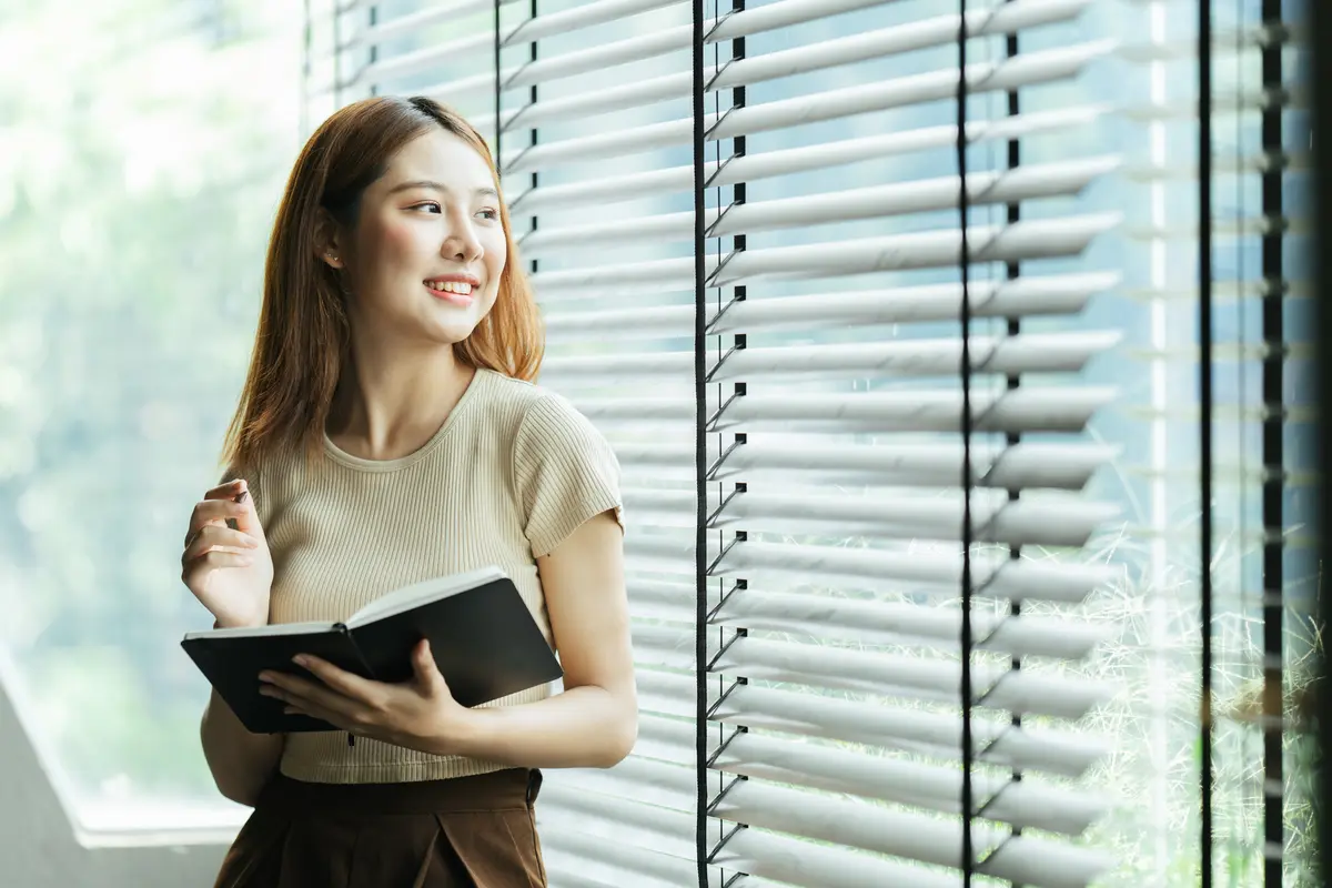 perempuan dan membawa buku