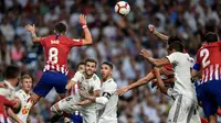 Bek Real Madrid, Nacho Fernandez, duel udara dengan gelandang Atletico Madrid, Saul Niguez, pada laga La liga di Stadion Santiago Bernabeu, Madrid, Sabtu (29/9/2018). Kedua klub bermain imbang 0-0. (AFP/Oscar Del Pozo)