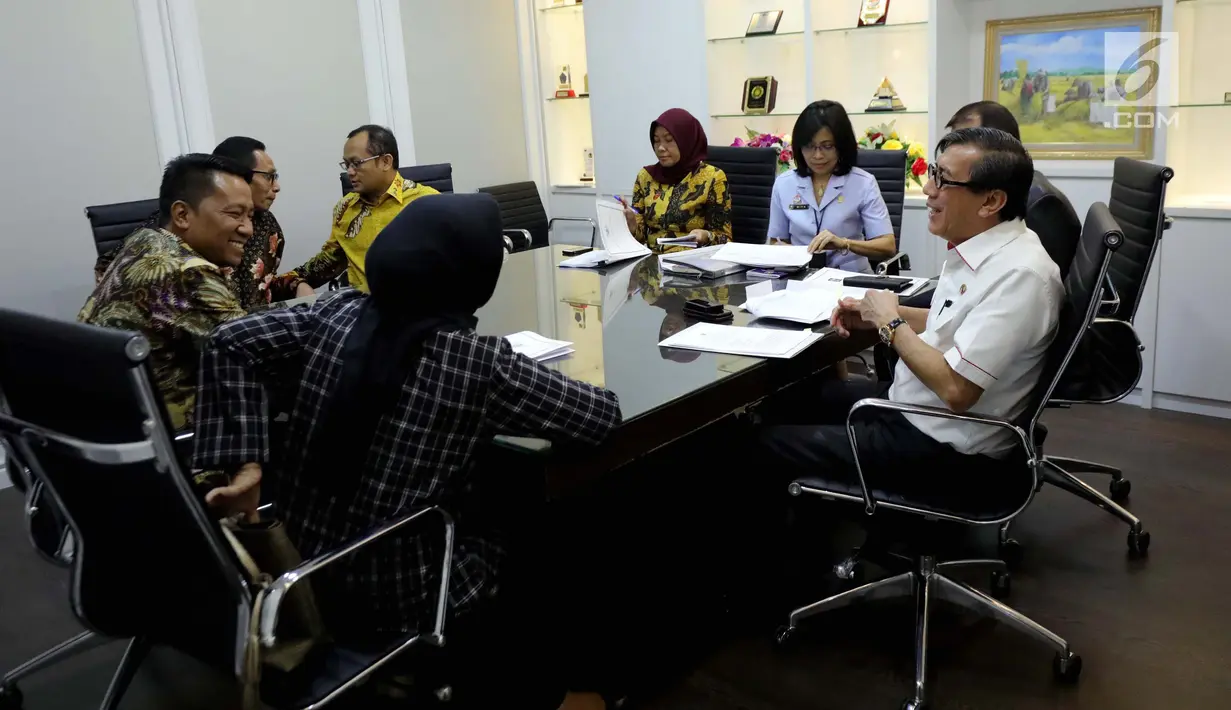 Menteri Hukum dan HAM Yasonna H Laoly berbincang dengan pimpinan Badan Legislasi (Baleg) sebelum melakukan rapat kerja di Gedung DPR, Jakarta, Selasa (23/10). Rapat dihadiri Anggota Baleg, Anggota DPD, dan pemerintah. (Liputan6.com/JohanTallo)