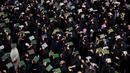 <p>Dalam ritual ini, umat Syiah melakukan ritual dengan menempatkan salinan Alquran di atas kepala mereka. (AP Photo/Anmar Khalil)</p>
