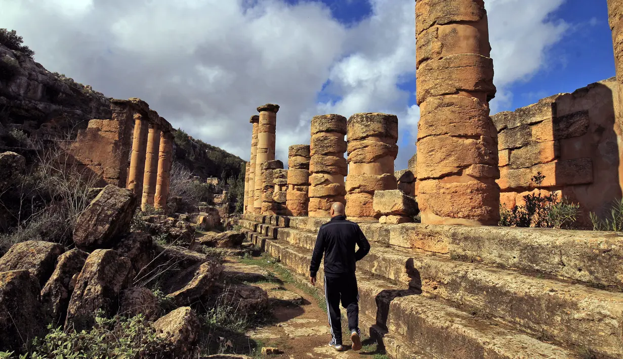 Seorang pria mengunjungi situs kota Yunani kuno Kirene di pinggiran kota Libya Shehhat (13/12/2019). Kirene juga merupakan tempat kelahiran Eratosthenes dan sejumlah filsuf seperti Kallimakhus, Karneades, Aristippus, Arete, Sinesius, dan uskup dari Ptolemais pada abad ke-4 M. (AFP/Abdullah Doma)