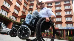 Pria asal Australia, Scott Doolan beraktivitas dengan kursi rodanya di Kathmandu, Nepal, Kamis (15/3). Scott Doolan ingin menjadi orang lumpuh pertama yang bisa mencapai Everest. (AFP Photo/Prakash Mathema)