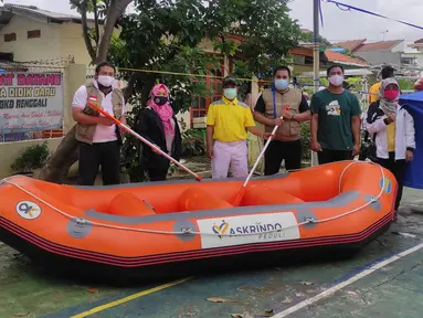 Karyawan PT. Askrindo secara simbolis memberikan bantuan perahu karet kepada warga korban banjir di Bekasi, Senin (22/02/2021). Bantuan perahu karet untuk proses evakuasi korban banjir diberikan di Pondok Timur Mas, Bekasi Selatan dan Perumnas III, Kota Bekasi. (Liputan6.com/Pool)