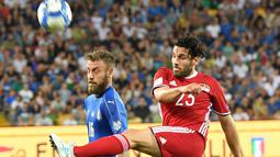 Pemain Italia, Daniele De Rossi (kiri) berduel dengan pemain Liechetenstein, Michele Polverino pada kualifikasi Piala Dunia 2018 grup G di Friuli Stadium, Udine, Italia, (11/6/2017).  (Alberto Lancia/ANSA via AP)