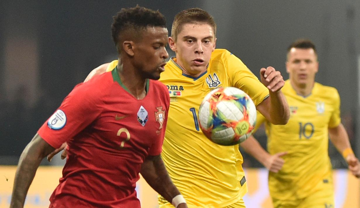 Bek Portugal, Nelson Semedo, berusaha melewati bek Ukraina, Vitaliy Mykolenko, pada laga Kualifikasi Piala Eropa 2020 di Stadion NSK Olimpiyskyi, Kiev, Senin (14/10). Ukraina menang 2-1 atas Portugal. (AFP/Genya Savilov)