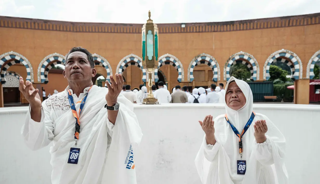 Diketahui, harga bahan bakar pesawat (avtur) mengalami lonjakan, dari Rp 13.656 menjadi Rp 23.551 per liter, sebagai imbas konflik yang terjadi di Timur Tengah. Tampak dalam foto, sepasang suami istri melakukan ritual di replika Ka'bah, saat mengikuti pelatihan di Pusat Pelatihan Manasik Al Mahmudah (AMTC), fasilitas pelatihan Haji yang menampilkan replika situs-situs ziarah utama, di Tangerang Selatan pada 5 April 2026. (YASUYOSHI CHIBA/AFP)