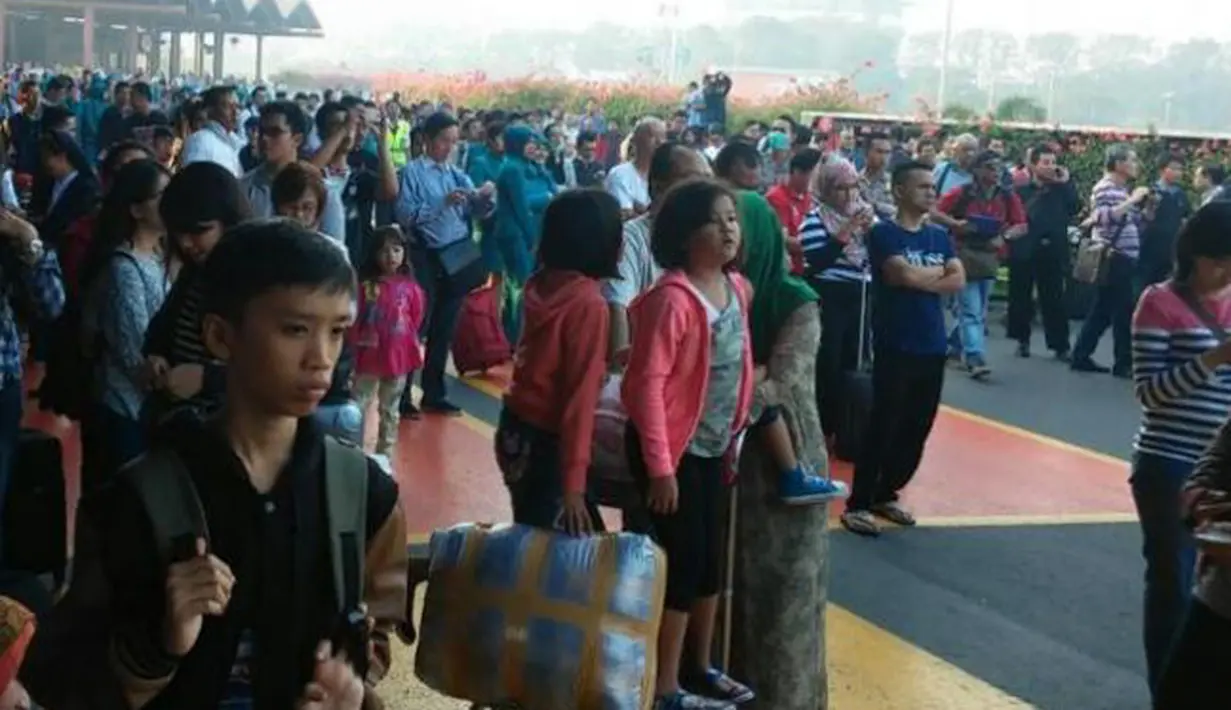 Sejumlah penumpang melihat kebakaran yang terjadi di Terminal 2E di Bandara Soekarno Hatta, Jakarta, Minggu (5/7/2015).  Kebakaran di Terminal 2E ini membuat panik ribuan penumpang yang sedang menunggu jadwal penerbangan. (Twitter@thisisyudhis)