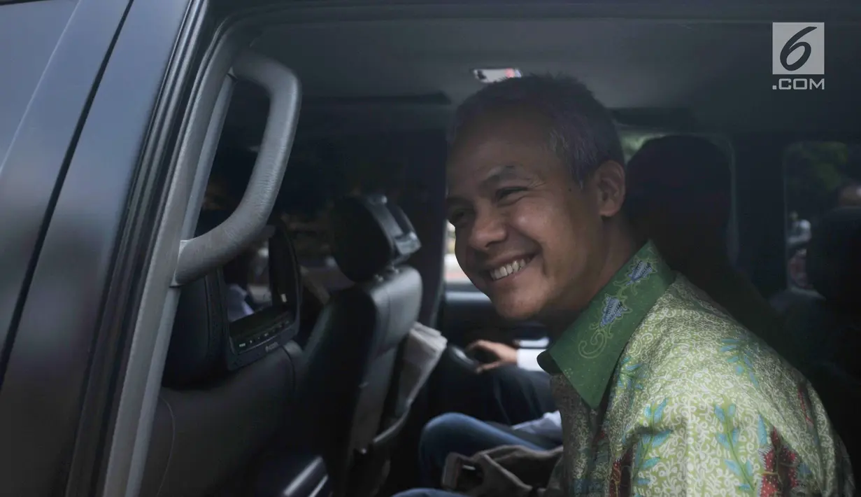 Gubernur Jawa Tengah Ganjar Pranowo tersenyum saat berada di dalam mobil usai diperiksa di gedung KPK, Jakarta, Selasa (4/7). Ganjar Pranowo diperiksa sebagai saksi untuk kasus dugaan korupsi proyek pengadaan e-KTP. (Liputan6.com/Helmi Afandi)