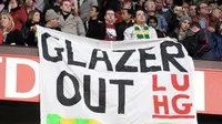Fans MU menggelar spanduk protes anti-Glazer di laga lanjutan EPL antara MU vs Portsmouth yang digelar di Old Trafford, 6 Februari 2010. AFP PHOTO / ANDREW YATES