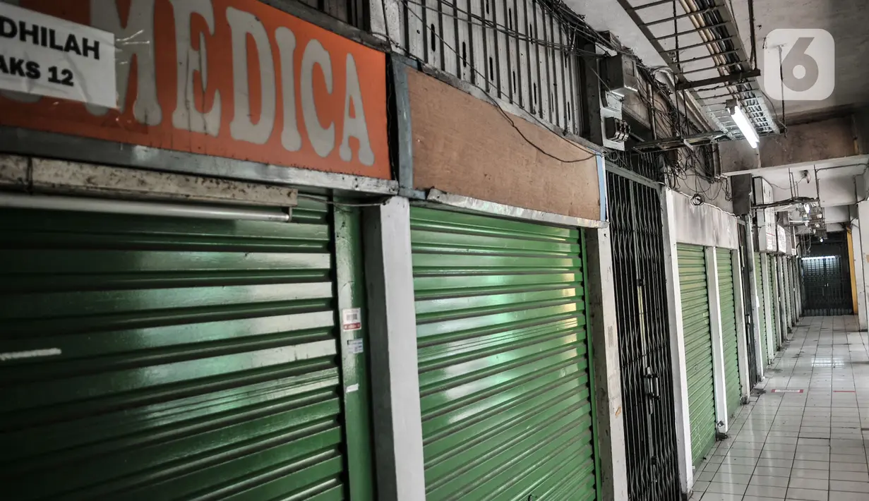 Deretan kios pedagang Pasar Pramuka saat ditutup sementara di Pasar Pramuka, Jakarta, Minggu (12/7/2020). Kegiatan jual beli di Pasar Pramuka ditiadakan selama tiga hari, mulai Sabtu (11/7) hingga Senin (13/7) setelah satu orang pedagang terkonfirmasi positif Covid-19. (merdeka.com/Iqbal Nugroho)