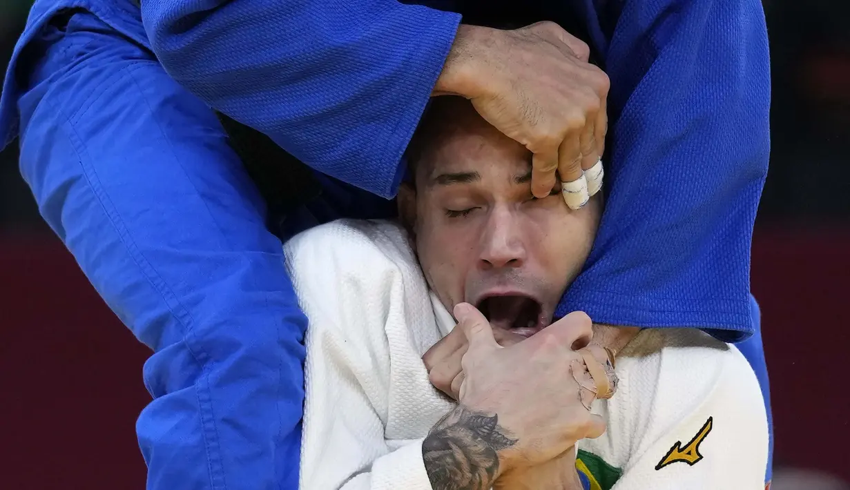 Pejudo asal Brasil, Daniel Cargnin (putih) bertanding melawan Mohamed Abdelmawgoud dari Mesir dalam pertandingan judo 66kg putra Olimpiade Tokyo 2020, Minggu (25/7/2021). (Foto: AP/Vincent Thian)