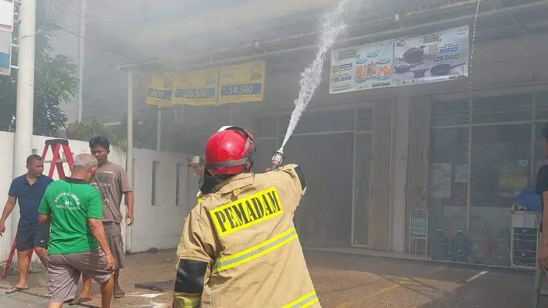 Pemadam kebakaran tengah memadamkan api yang melalap Indomaret di di Jalan Kramat 4 Senen, Jakarta Pusat.