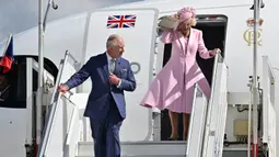 Raja Inggris Charles III (kiri) dan Ratu Inggris Camilla saat turun dari pesawat setibanya di Bandara Orly pada 20 September 2023. (Miguel MEDINA/POOL/AFP)