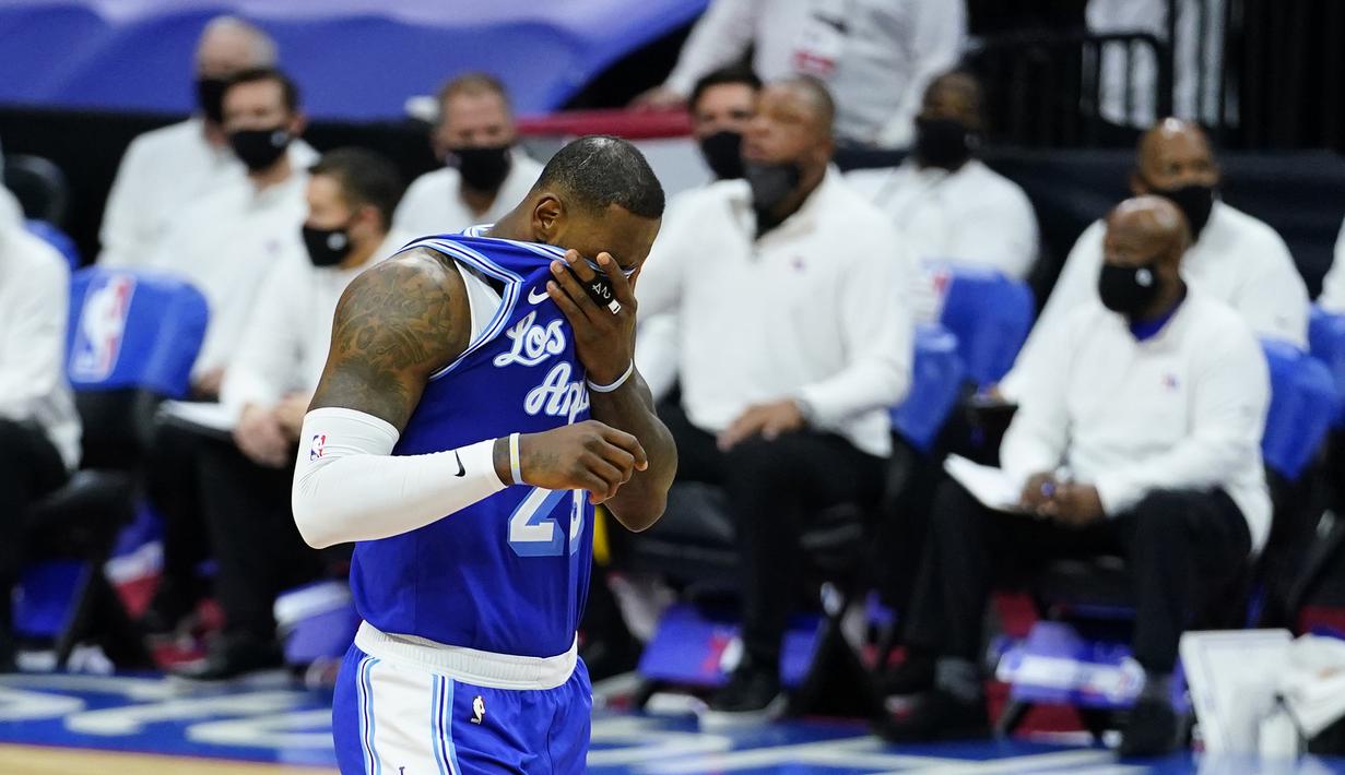 Pebasket LA Lakers, LeBron James menutup wajahnya pada laga lanjutan NBA melawan Philadelphia 76ers di Wells Fargo Center Arena, Philadelphia, AS, Kamis (28/1/2021). (Foto: AP Photo/Matt Slocum)
