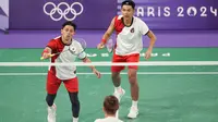 Pemain ganda putra Indonesia, Muhammad Rian Ardianto (kiri) mengembalikan bola serve saat menghadapi wakil Prancis, Lucas Corvee/Ronan Labar pada laga Grup C Olimpiade Paris 2024 di Porte De La Chapelle Arena, Paris, Senin (29/7/2024). Fajar Alfian/Muhammad Rian Ardianto menang dua gim langsung 21-13, 21-10. (Dok. NOC Indonesia/Naif Muhammad Al'as)