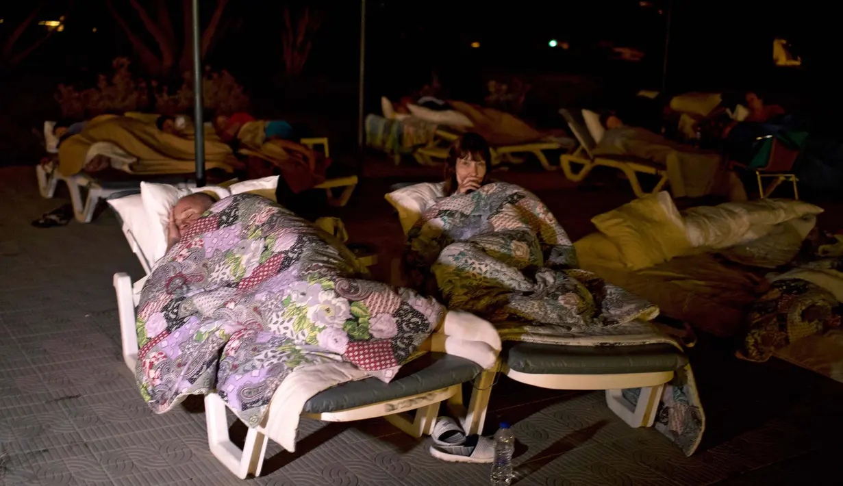 Warga tidur di taman bermain setelah gempa bumi 6,5 SR melanda Pulau Kos, Yunani, Sabtu (22/7). Gempa yang melukai 500 orang dan menewaskan dua orang membuat warga memilih tidur di luar rumah karena takut gempa susulan. (AP Photo/Petros Giannakouris)