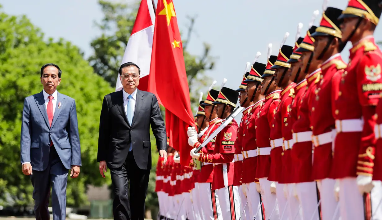 Presiden Jokowi bersama Perdana Menteri China Li Keqiang memeriksa pasukan saat kunjungan kenegaraan di Istana Bogor, Senin (7/5). Kerja sama perdagangan dan investasi merupakan isu utama yang akan dibahas Li dan Jokowi. (Mast Irham/Pool via AP)