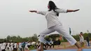 Instruktur memeragakan gerakan yoga dihadapan ribuan personel Angkatan Darat India saat melakukan senam di Ahmedabad, India, Senin (20/6). Kegiatan ini untuk memeriahkan perayaan Hari Yoga Internasional. (AFP PHOTO/Sam Panthaky)