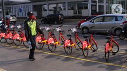 Petugas keamanan melintas di dekat deretan sepeda untuk layanan bike sharing atau penyewaan sepeda di Kawasan Jakarta, Jumat (3/7/2020). Layanan bike sharing yang bertujuan untuk mengurangi penggunaan kendaraan bermotor ini terbagi dalam 6 titik lokasi di Jakarta. (Liputan6.com/Angga Yuniar)