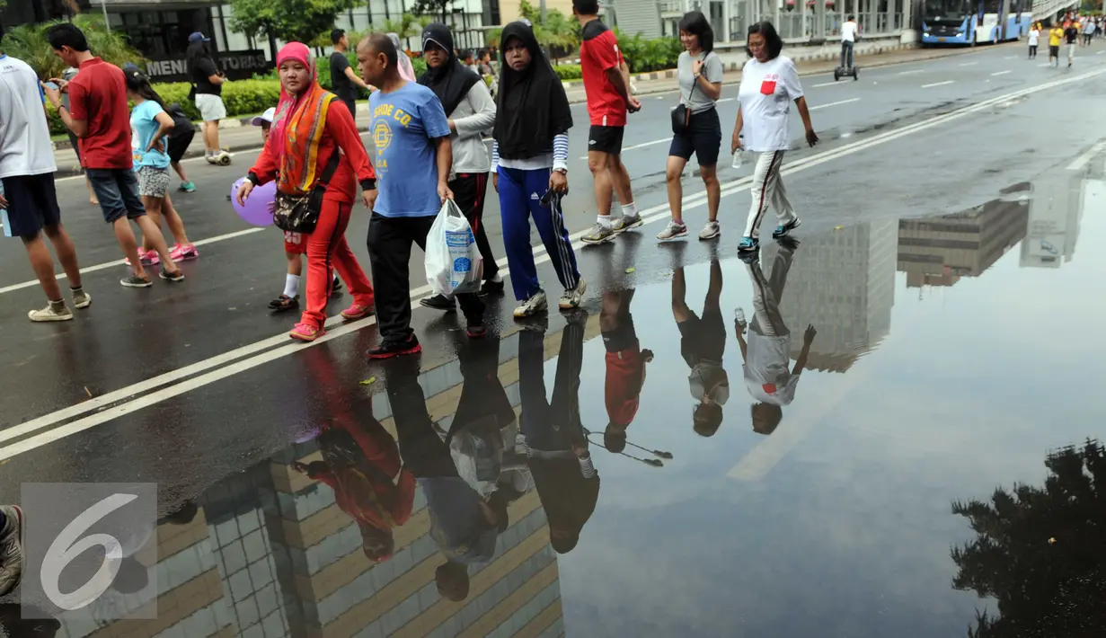 Warga memadati Jalan M.H. Thamrin saat kegiatan Car Free Day di Jakarta, Minggu (24/1/2016). Meski hujan mengguyur Ibu Kota sejak semalam, kegiatan CFD pagi di kawasan Bundaran Hotel Indonesia masih tetap ramai. (Liputan6.com/Helmi Affandi)