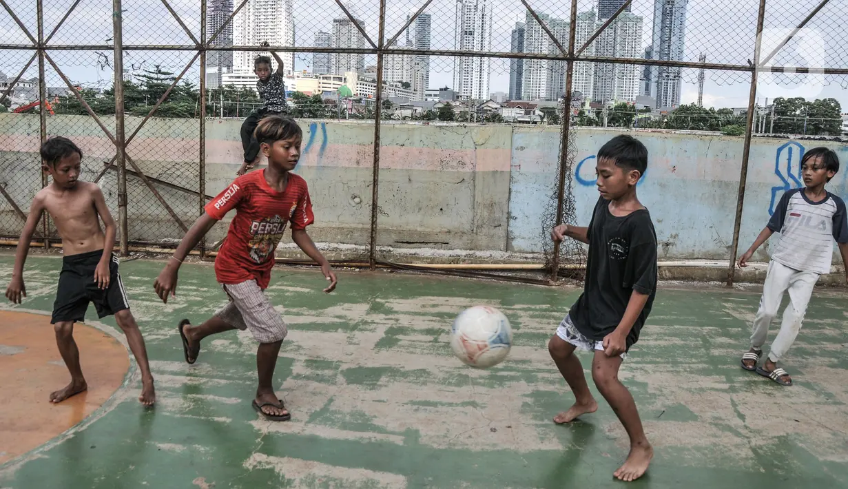 Anak-anak saat bermain dengan latar belakang gedung bertingkat di kawasan Petamburan, Jakarta, Selasa (23/11/2021). Kenaikan pendapatan negara mengindikasikan pemulihan ekonomi terus berlanjut. (merdeka.com/Iqbal S. Nugroho)