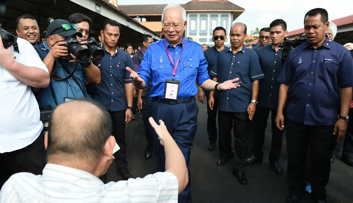 Perdana Menteri Malaysia, Najib Razak menyapa seorang pendukung di tempat pemungutan suara selama pemilihan umum di Pekan, Rabu (9/5). Pemilu ini pertarungan antara PM Najib yang sudah berkuasa sejak 2009, melawan Mahathir Mohamad. (MOHD RASFAN / AFP)