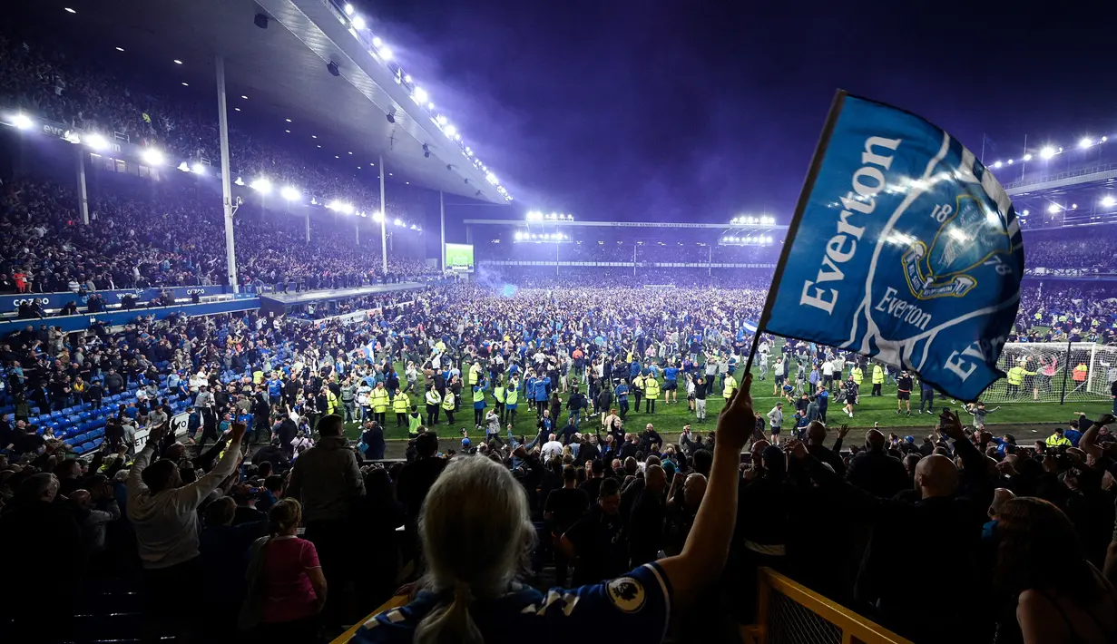 <p>Suporter Everton menyerbu lapangan untuk merayakan akhir pertandingan Liga Inggris antara Everton dan Crystal Palace di Goodison Park di Liverpool, Inggris, 19 Mei 2022. Everton berhasil menang lewat come back dramatis 3-2 dan keluar dari zona degradasi Liga Inggris. (AFP/Oli Scarff)</p>