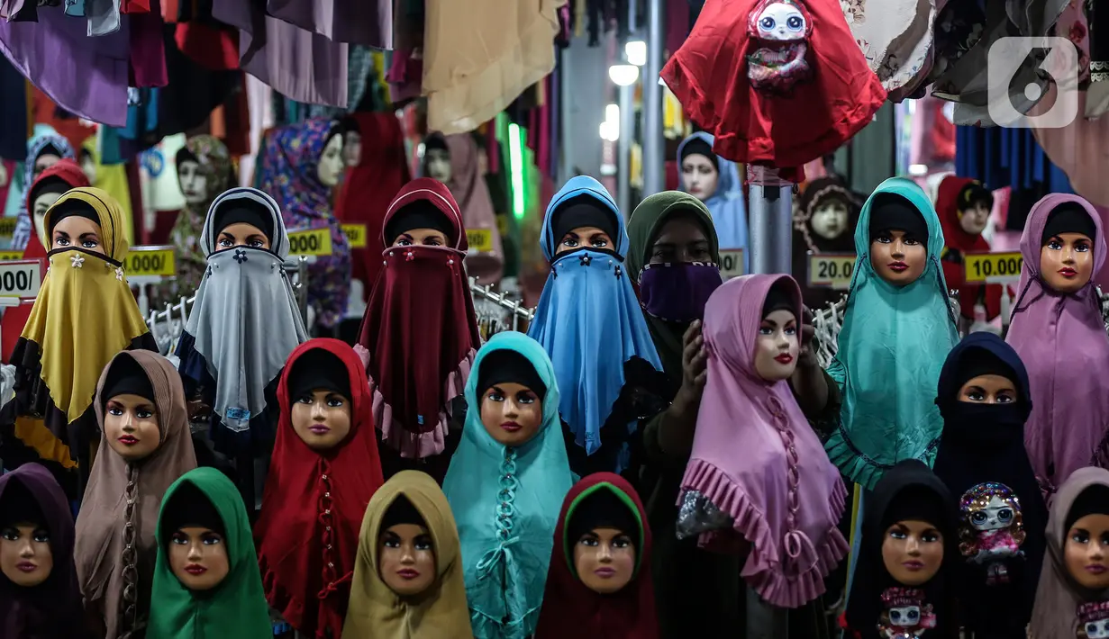 Aktivitas jual beli gamis dan baju anak menunggu pembeli di kiosnya di pasar Parung, Bogor, Jawa Barat, Kamis (18/2/2021). Akibat menurunnya omset penjualan gamis dan baju anak selama pandemi COVID-19, pedagang rela menurunkan harga agar menarik perhatian pembeli. (Liputan6.com/Johan Tallo)