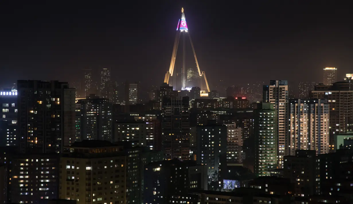 Pemandangan saat puncak hotel Ryugyong dihiasi bendera Korea Utara di kota Pyongyang, Korea Utara (9/4). (AFP Photo/Ed Jones)