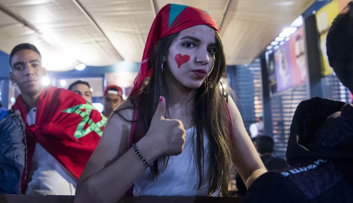 Seorang wanita cantik berpesta merayakan keberhasilan negaranya lolos ke Piala Dunia 2018 di Rabat, Sabtu (11/11/2017). Maroko lolos setelah mengalahkan Pantai Gading 2-0 pada laga penentu. (AFP/Fadel Senna)