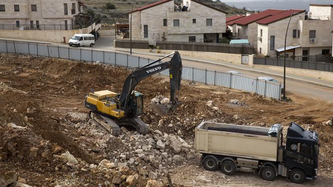 Alat berat bekerja di situs konstruksi di permukiman Yahudi di Tepi Barat (AP)