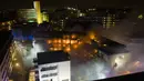 Petugas pemadam kebakaran memadamkan api di kompleks perumahan di Essen Jerman, Senin (21/2/2022). Dinas pemadam kebakaran mengatakan bahwa sekitar 100 orang dievakuasi dari kompleks apartemen tersebut. (Stephan Witte/KDF-TV/dpa via AP)