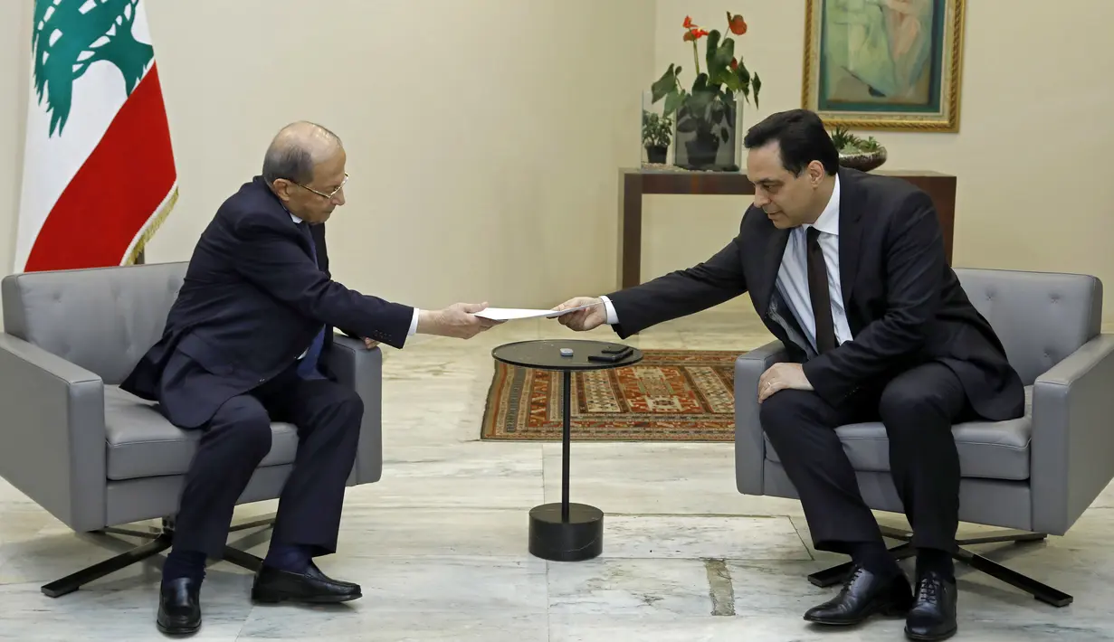 PM Lebanon, Hassan Diab (kanan) mengajukan pengunduran dirinya kepada Presiden Michel Aoun di istana presiden di Baabda, ibu kota Beirut pada 10 Agustus 2020. Pengunduran diri Diab dilakukan di tengah kemarahan rakyat atas ledakan besar di Beirut pada 4 Agustus lalu. (HO/DALATI AND NOHRA/AFP)