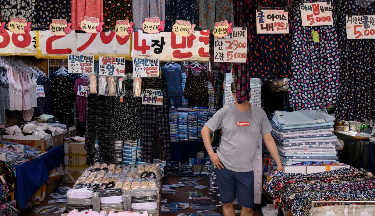 Seorang pedagang pakaian menunggu pembeli di sebuah toko di pasar Namdaemun di Seoul (2/7/2019). Pasar ini sangat populer bagi para wisatawan asing yang berkunjung ke Seoul. (AFP Photo/Minji Suh)