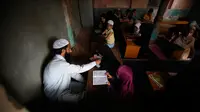 Anak-anak Kashmir saat menghadiri kelas pembacaan Al-Quran di sebuah madrasah lokal selama bulan Ramadan di Srinagar, Kashmir yang dikuasai India, (30/5). Di bulan puasa umat muslim menahan diri untuk tidak makan dan minum. (AP Photo / Mukhtar Khan)