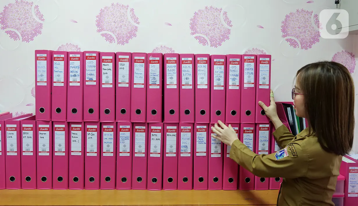Bendahara Pengeluaran Kelurahan Rawa Bunga, Annastasia Sindi beraktivitas di ruang kerjanya di kantor kelurahan Rawa Bunga, Jakarta, Senin (7/10/2019). Annastasia Sindi merubah warna kesukaannya warna pink (merah muda)  untuk menyemangati dalam bekerja. (Liputan6.com/Herman Zakharia)
