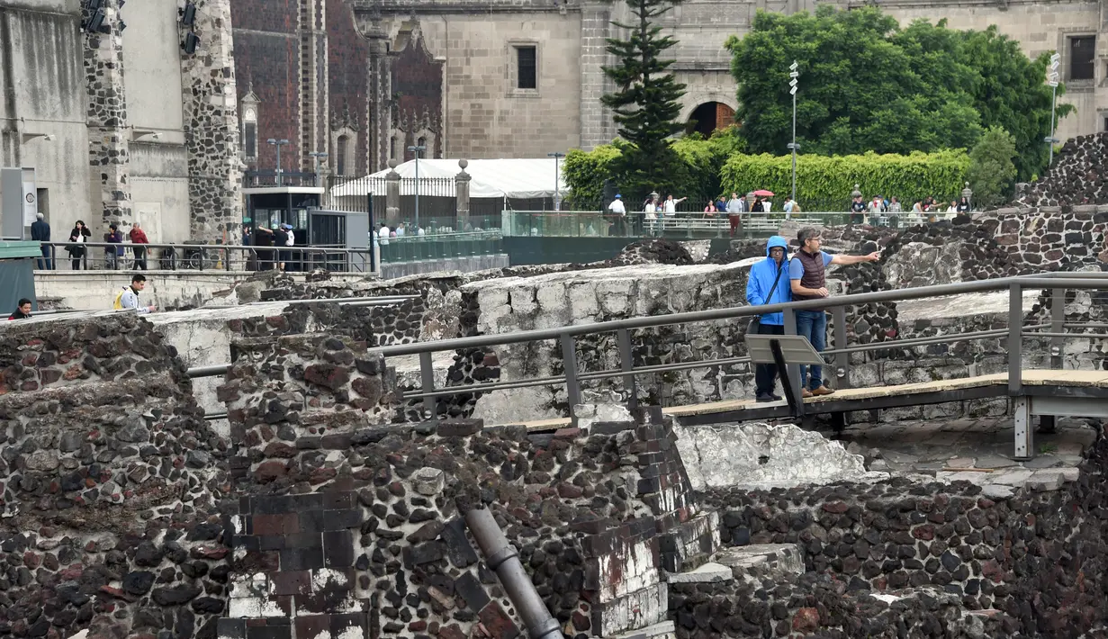 Pengunjung berjalan di Templo Mayor di kota Meksiko, (12/8). Templo Mayor dibangun setelah tahun 1325, dan setelah itu dibangun kembali sebanyak enam kali. (AFP Photo/Rodrigo Arangua)