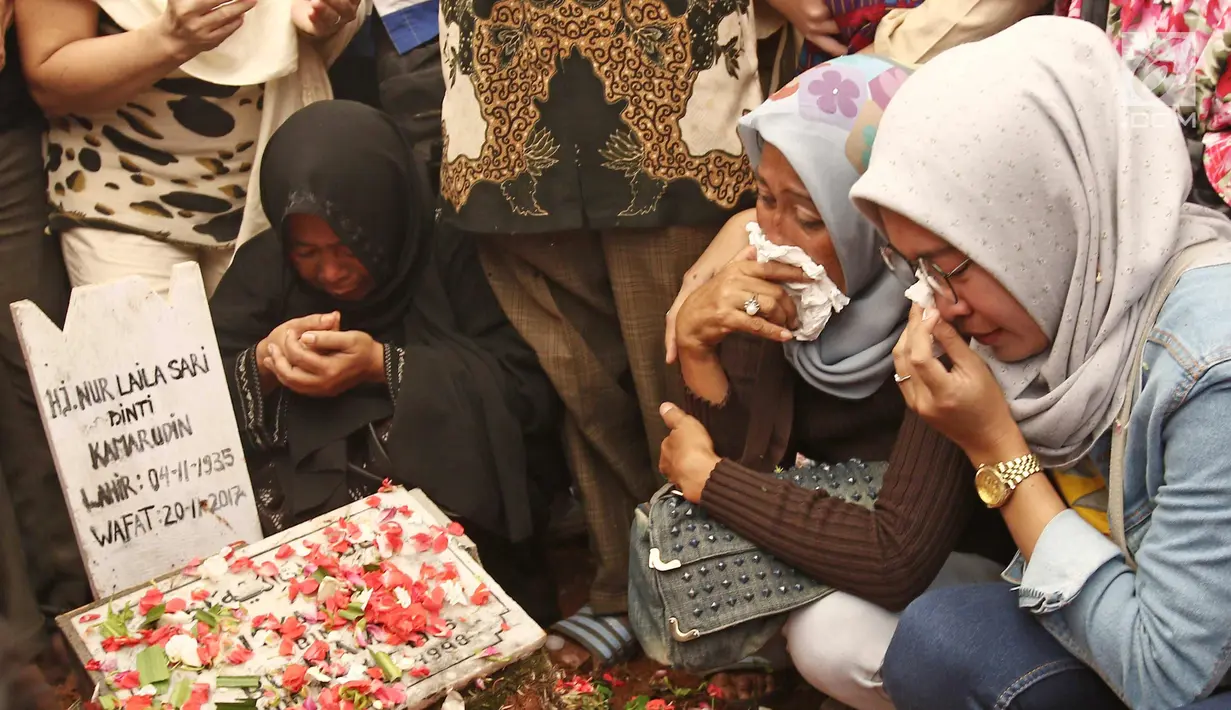 Kerabat dan keluarga menangis  saat  dipemakaman Laila Sari di Tempat Pemakaman Umum (TPU) Karet Bivak, Jakarta, Selasa (21/11). Laila Sari meninggal dunia saat pulang syuting, di usai 82 tahun. (Liputan6.com/Herman Zakharia)