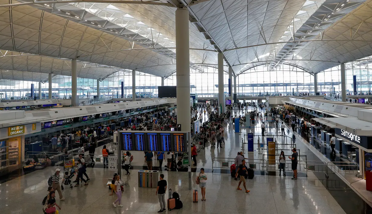 Calon penumpang memadati loket check in di bandara Hong Kong, Rabu (14/8/2019). Bandara Hong Kong kembali membuka penerbangan keberangkatan pada Rabu pagi setelah sempat lumpuh selama dua hari akibat demonstran menduduki salah satu bandara tersibuk di dunia tersebut. (AP/Vincent Thian)