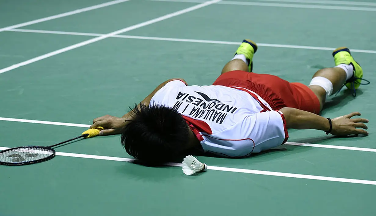 Pebulutangkis Indonesia, Ihsan Maulana Mustofa, terjatuh  saat melawan pebulutangkis Denmark, Hans-Kristian Vittinghus, pada final Piala Thomas di Kunshan, China, Minggu (22/5/2016). Indonesia kalah 2-3 oleh Denmark. (AFP/Johannes Eisele)